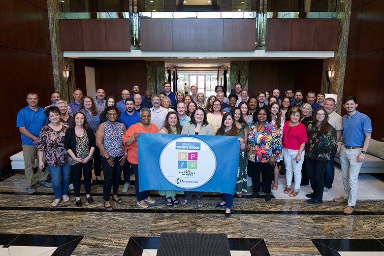 company staff holding up Best Places to Work Banner